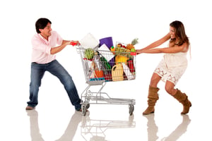 Couple fighting over a shopping cart - isolated over white