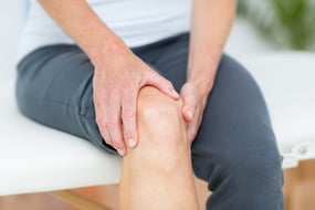 Woman having knee pain in medical office