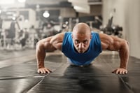 bodybuilder working out and doing push upsat the gym while
